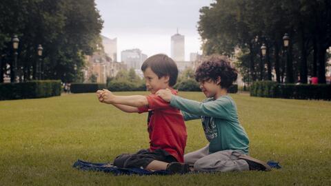 Foto zum Film: Zwei Jungen spielen miteinander in einem Park im Stadtteil Molenbeek